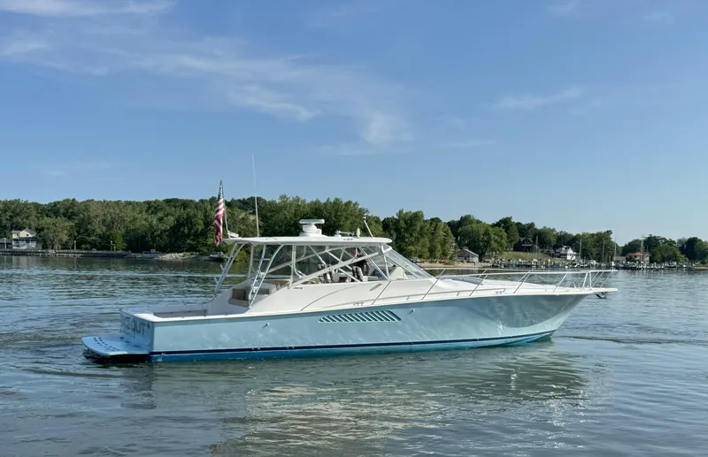 Slide: The Image of 2007 Viking 52 Open yacht on calm water, surrounded by lush greenery. - 2