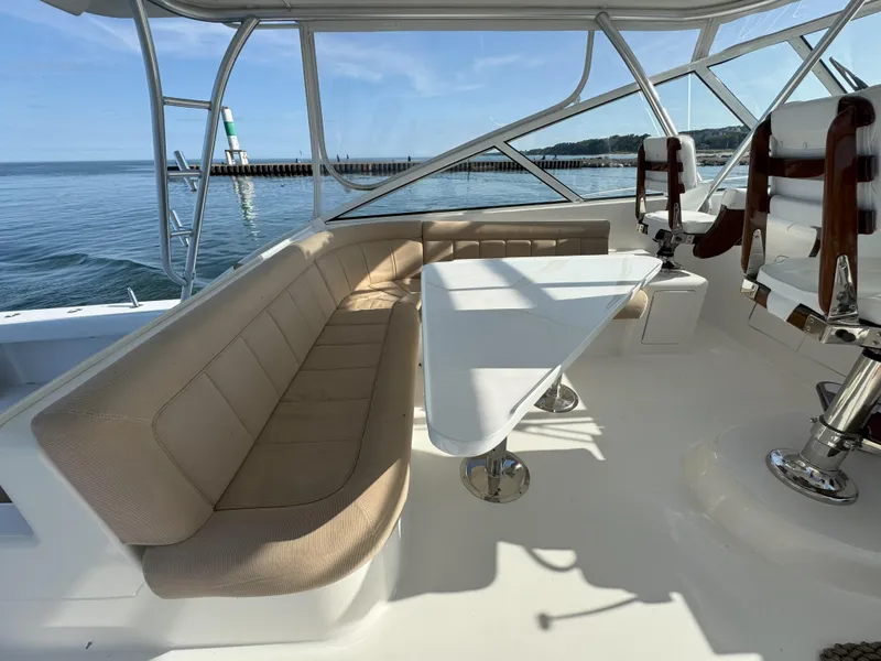 Slide: The Image of 2007 Viking 52 Open yacht interior with seating and table, overlooking calm waters. - 20