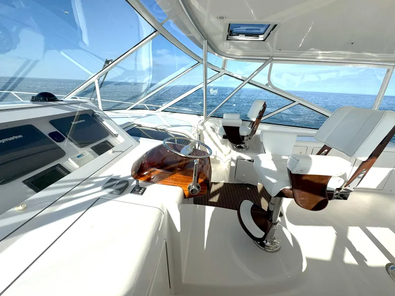 Slide: The Image of 2007 Viking 52 Open yacht helm with white seating and ocean view. - 24