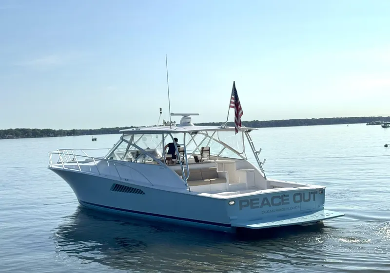 Slide: The Image of 2007 Viking 52 Open yacht on calm water, displaying "Peace Out" on the stern. - 3