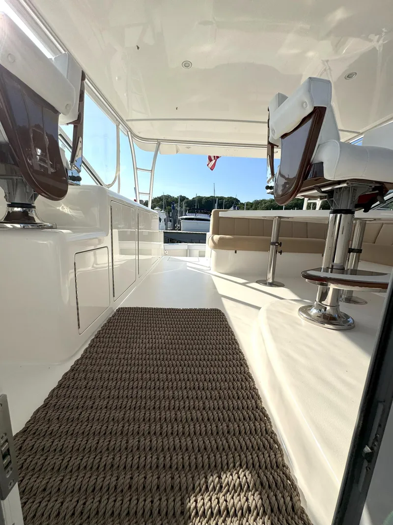 Slide: The Image of 2007 Viking 52 Open yacht interior with seating and helm chairs, featuring a woven rug. - 30