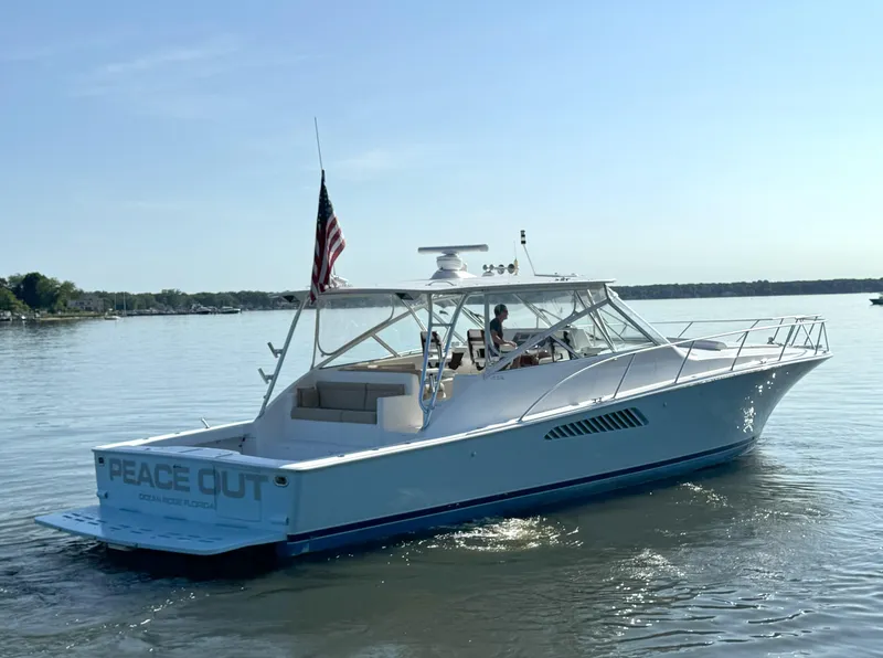 Slide: The Image of 2007 Viking 52 Open yacht on calm water, displaying "Peace Out" and American flag. - 4