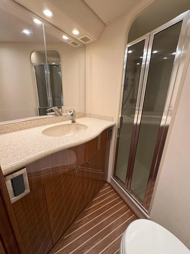 Slide: The Image of Luxurious bathroom in 2007 Viking 52 Open yacht with modern fixtures and wood accents. - 46
