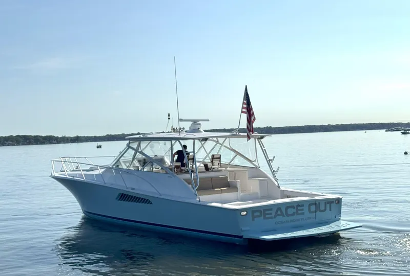Slide: The Image of 2007 Viking 52 Open yacht on calm water, displaying "Peace Out" on the stern. - 5