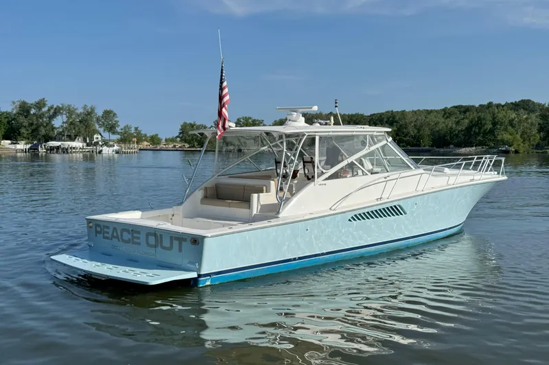 Slide: The Image of 2007 Viking 52 Open yacht on calm water, featuring "Peace Out" on the stern. - 6