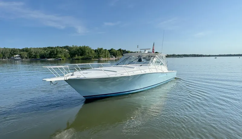 Slide: The Image of 2007 Viking 52 Open yacht on calm water, clear sky, and lush shoreline. - 7