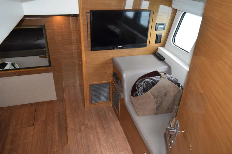 Slide: The Image of 2018 Cruisers Yachts 45 Cantius interior with TV, seating, and wooden flooring. - 15