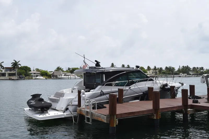 Slide: The Image of 2018 Cruisers Yachts 45 Cantius docked by waterfront homes. - 2