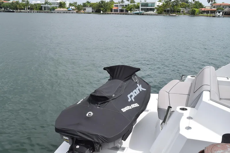 Slide: The Image of 2018 Cruisers Yachts 45 Cantius with covered Sea-Doo Spark on deck, near waterfront homes. - 7