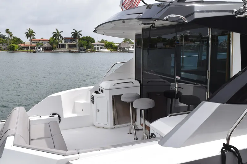Slide: The Image of 2018 Cruisers Yachts 45 Cantius, luxury yacht interior with seating, docked by waterfront homes. - 8