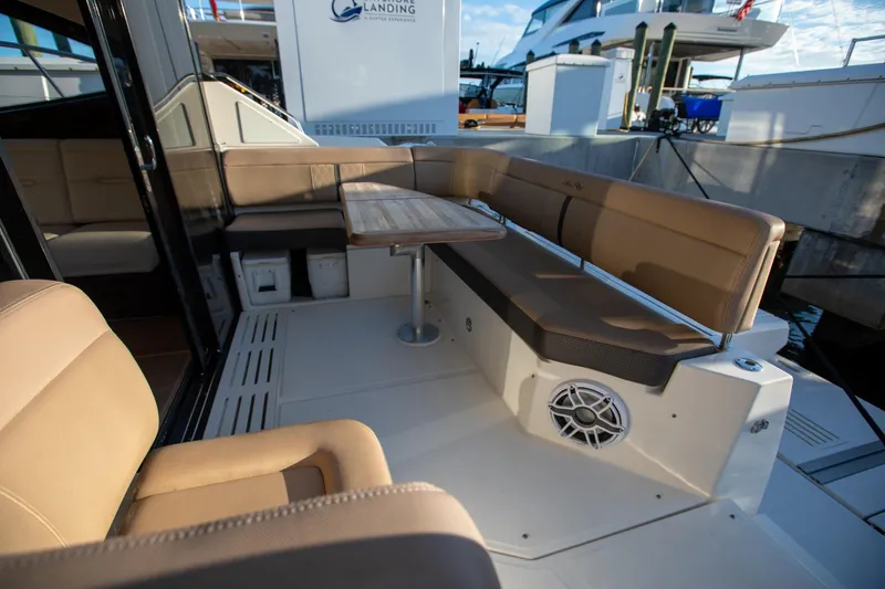 Slide: The Image of Luxurious seating area on 2018 Sea Ray Sundancer 400 yacht, featuring beige upholstery and a wooden table. - 24