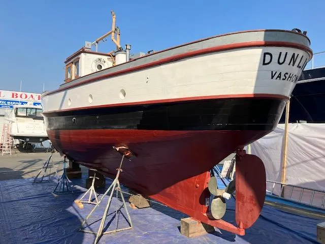 Slide: The Image of 1920 Blanchard Dunlin 42 boat on dry dock, Vashon, with red and black hull. - 22