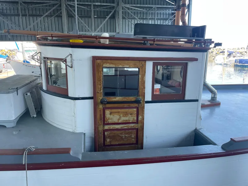 Slide: The Image of 1920 Blanchard Dunlin 42 boat cabin with wooden door, docked in a marina. - 6