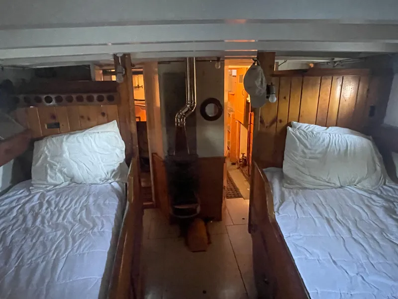 Slide: The Image of Cozy cabin interior of 1920 Blanchard Dunlin 42 with wooden paneling and twin beds. - 9