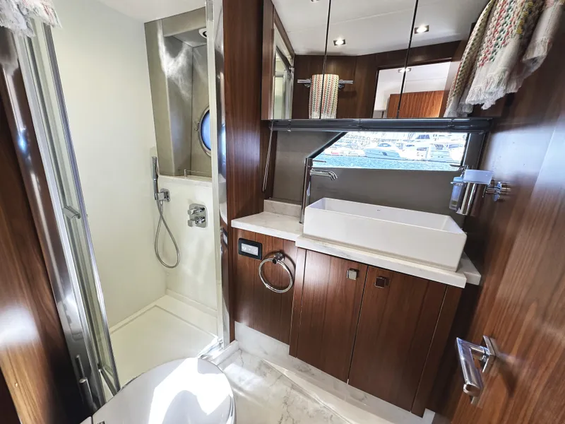 Slide: The Image of Luxurious bathroom in 2019 Sunseeker Predator 57 yacht with modern fixtures and wood accents. - 48