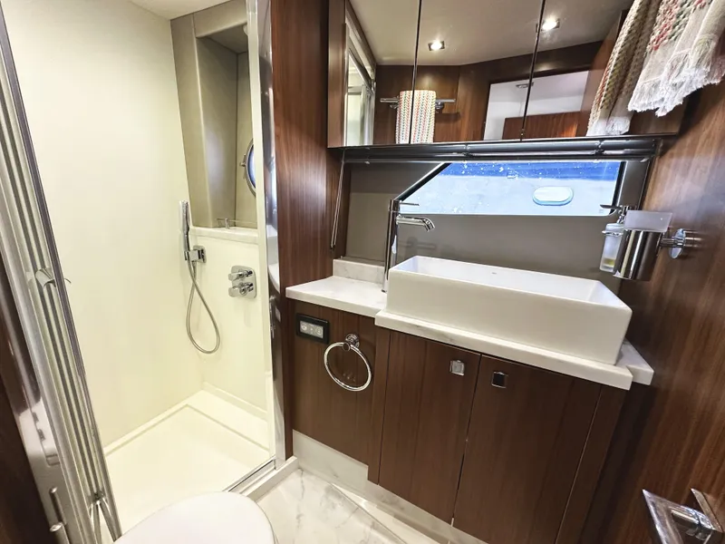 Slide: The Image of Luxurious bathroom in 2019 Sunseeker Predator 57 yacht with modern fixtures and wood accents. - 49