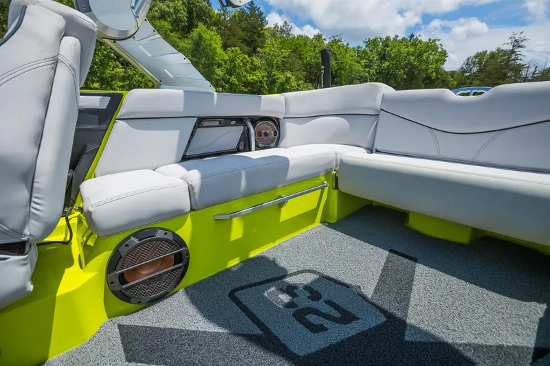 Slide: The Image of 2018 MasterCraft X23 boat interior with white seating and vibrant green accents. - 14