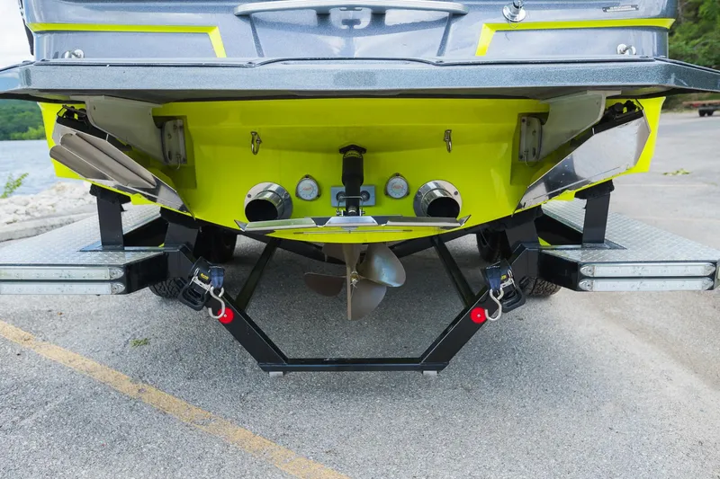 Slide: The Image of Rear view of a 2018 MasterCraft X23 boat on a trailer, showcasing propeller and hull design. - 19