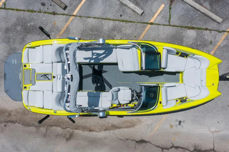 Slide: The Image of 2018 MasterCraft X23 boat, aerial view, vibrant yellow exterior, spacious seating layout. - 2