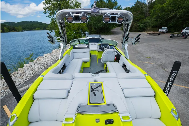 Slide: The Image of 2018 MasterCraft X23 boat with vibrant interior, docked by a scenic lake. - 26