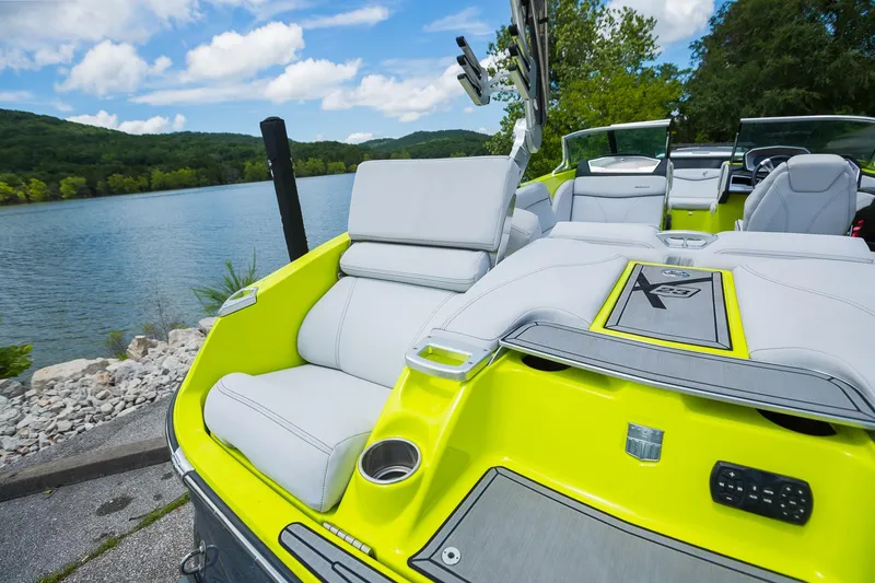 Slide: The Image of 2018 MasterCraft X23 boat with sleek seating, docked by a scenic lake. - 27