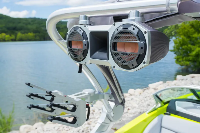 Slide: The Image of 2018 MasterCraft X23 boat with mounted speakers and wakeboard rack by a lake. - 28