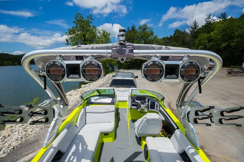 Slide: The Image of 2018 MasterCraft X23 boat with vibrant interior and advanced sound system by a scenic lake. - 29