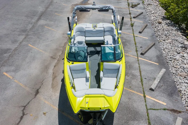 Slide: The Image of 2018 MasterCraft X23 boat, bright yellow, parked on concrete with seating visible. - 5