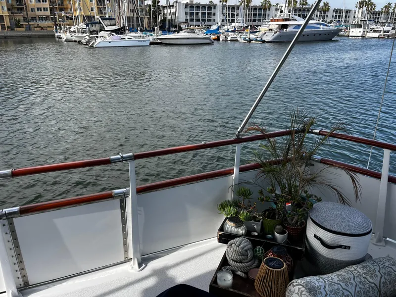 Slide: The Image of 1965 Hatteras 41 Twin Cabin deck with plants, overlooking marina with docked boats. - 10