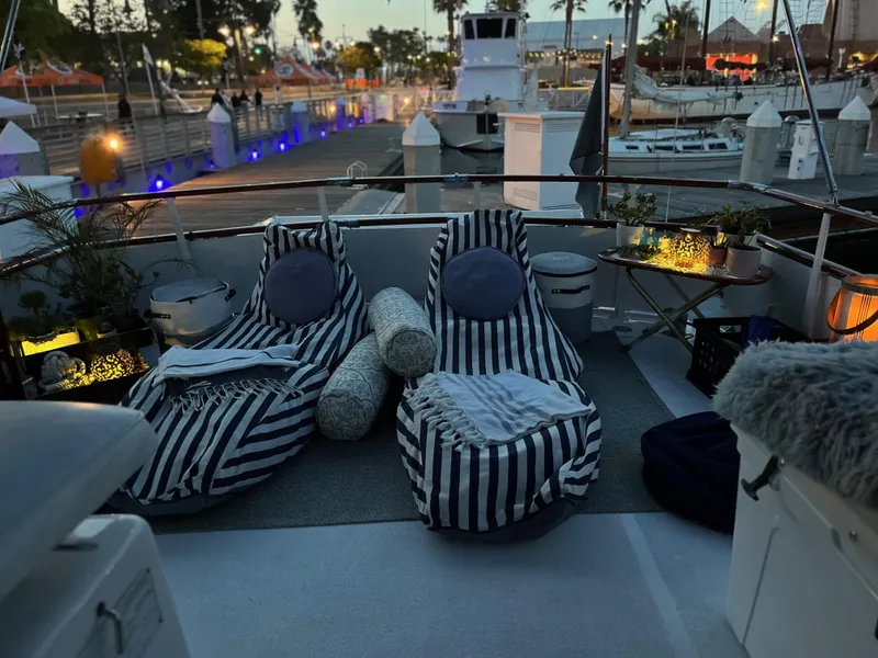 Slide: The Image of Cozy deck setup on 1965 Hatteras 41 Twin Cabin with striped loungers and ambient lighting. - 11