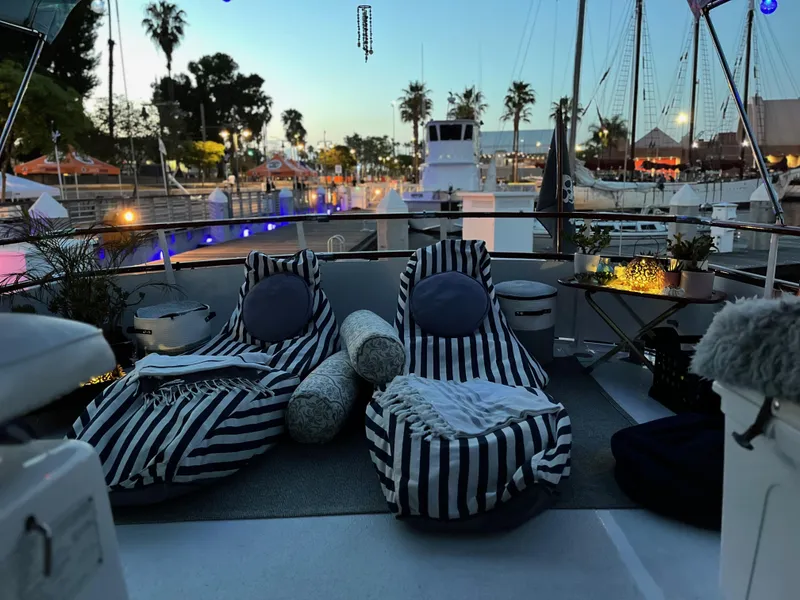 Slide: The Image of Cozy deck setup on 1965 Hatteras 41 Twin Cabin yacht at sunset, featuring striped loungers. - 12