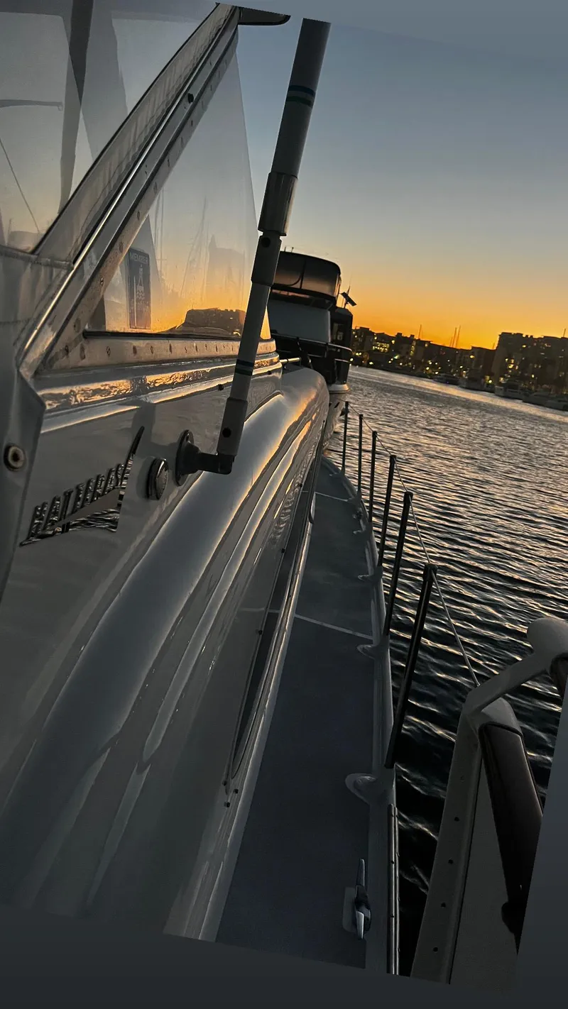 Slide: The Image of 1965 Hatteras 41 Twin Cabin yacht at sunset, docked by the waterfront. - 13