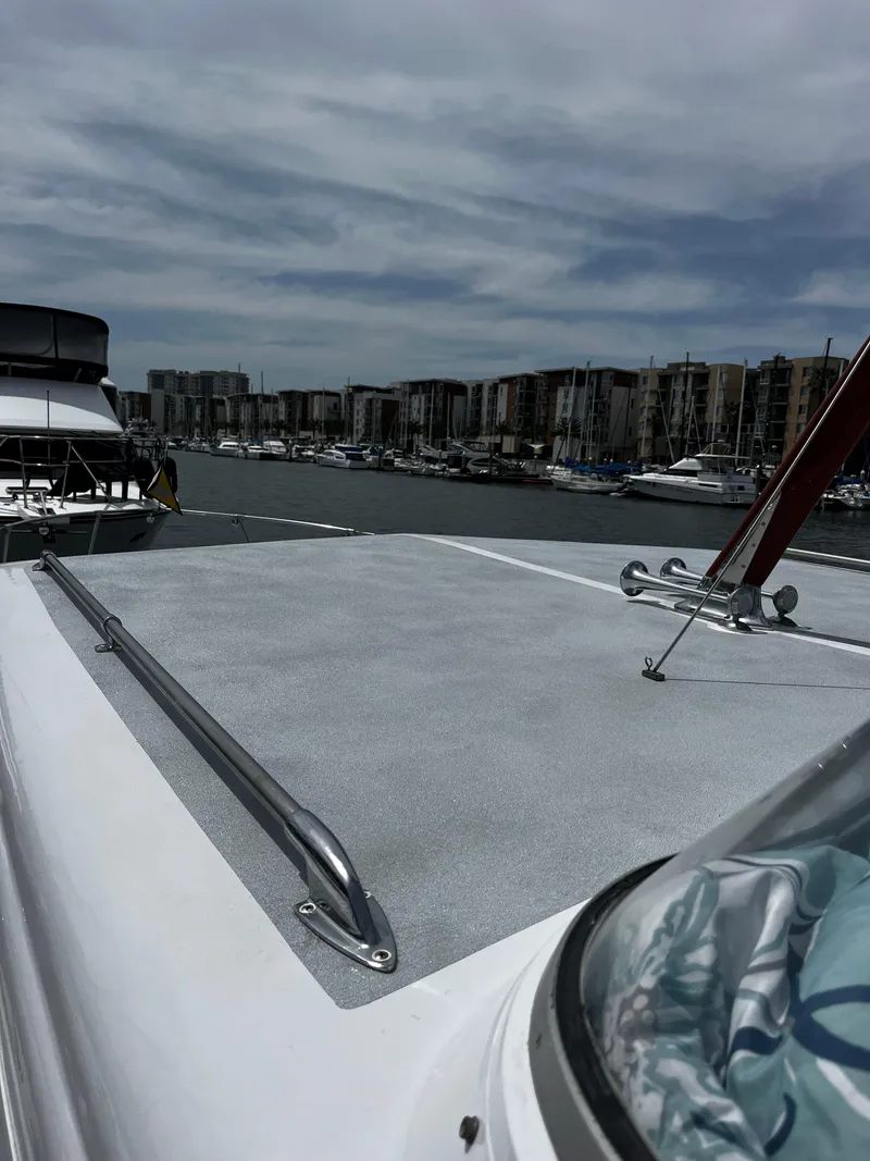Slide: The Image of 1965 Hatteras 41 Twin Cabin yacht deck with marina view under cloudy sky. - 15