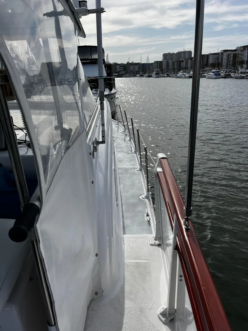 Slide: The Image of 1965 Hatteras 41 Twin Cabin yacht docked in a marina, side view with water reflections. - 18