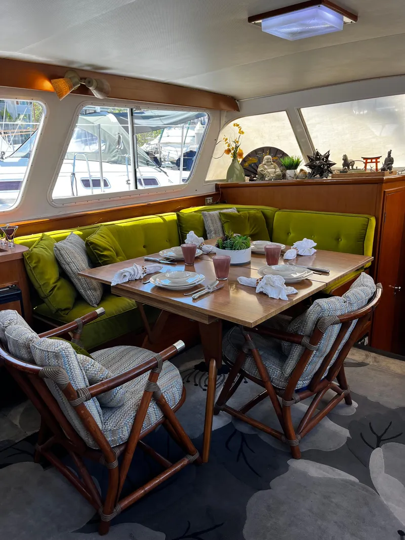Slide: The Image of Interior of 1965 Hatteras 41 Twin Cabin with elegant dining setup and green seating. - 20