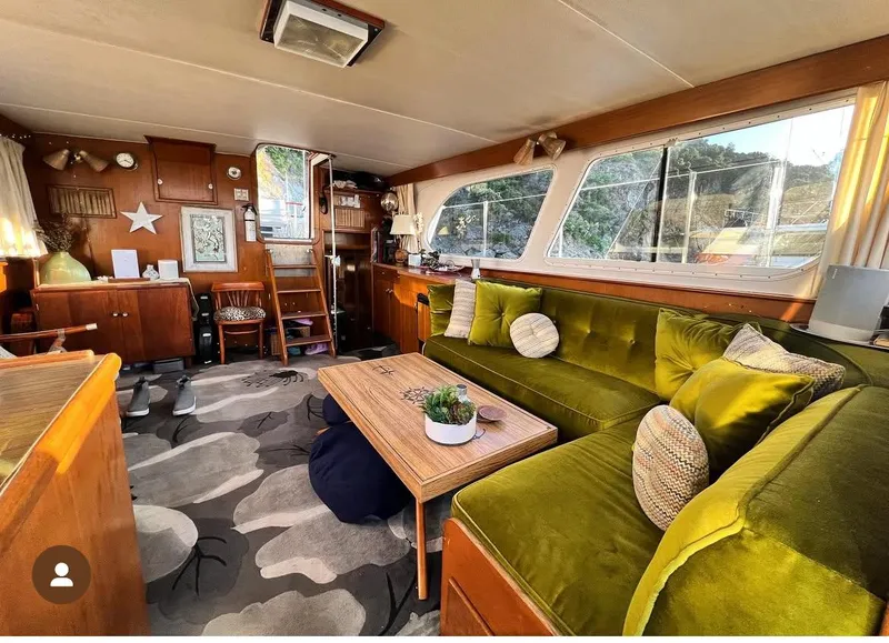 Slide: The Image of Cozy interior of a 1965 Hatteras 41 Twin Cabin with green velvet seating and wooden accents. - 23