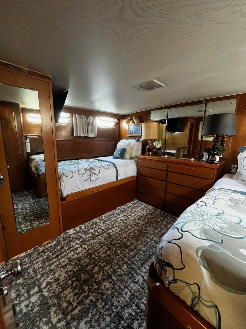 Slide: The Image of 1965 Hatteras 41 Twin Cabin interior with twin beds, wooden furniture, and floral bedding. - 31