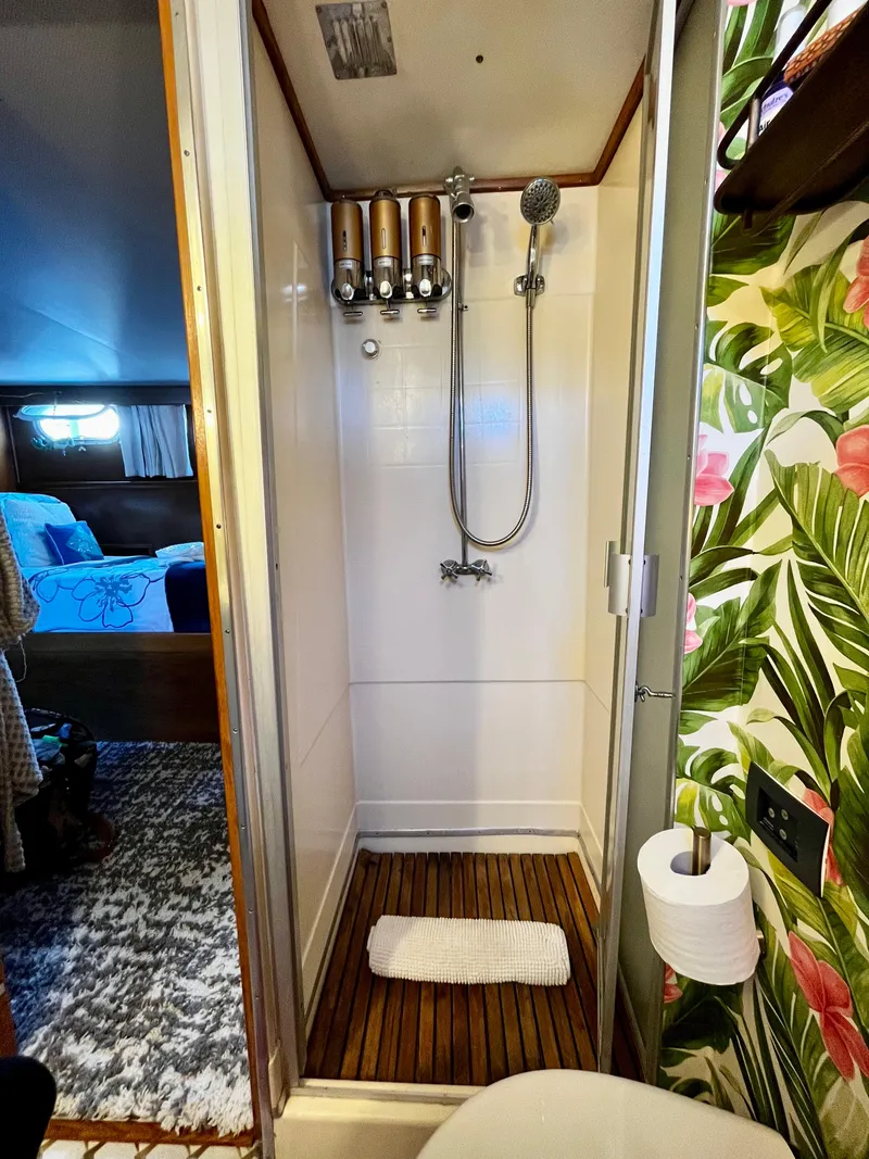 Slide: The Image of Shower area in 1965 Hatteras 41 Twin Cabin with floral wallpaper and wooden floor mat. - 37