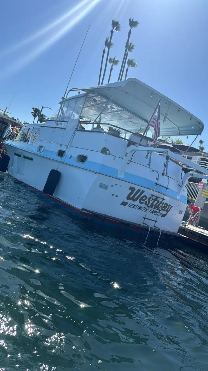 Slide: The Image of 1965 Hatteras 41 Twin Cabin boat docked, sunny day, palm trees in background. - 8