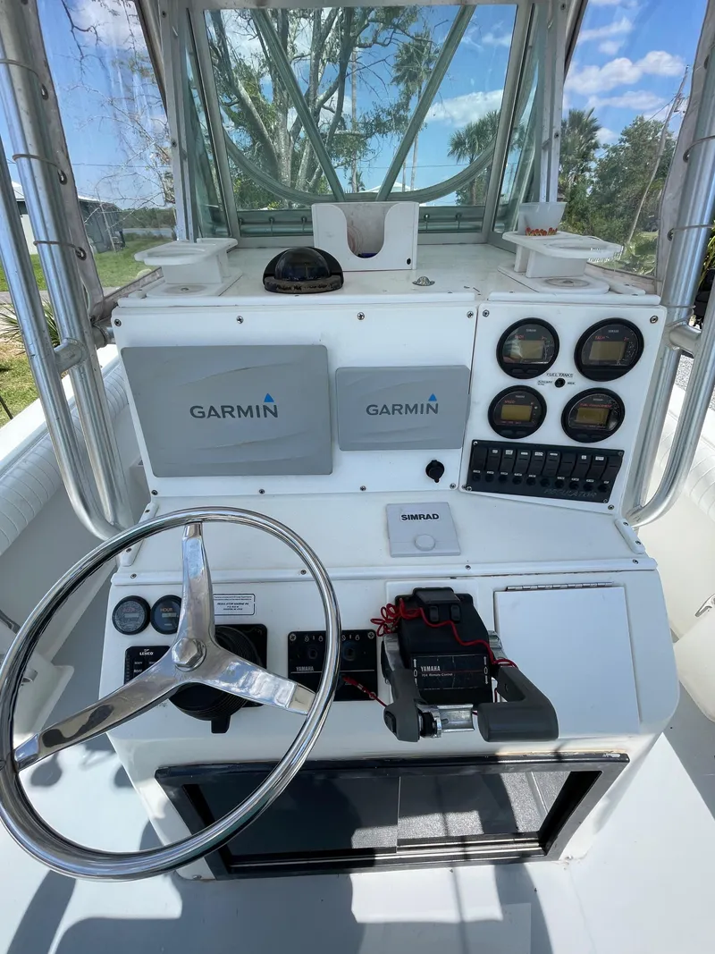 Slide: The Image of 1998 Regulator 26 Classic boat helm with Garmin electronics and steering wheel. - 15