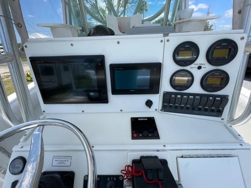 Slide: The Image of 1998 Regulator 26 Classic boat dashboard with navigation screens and gauges. - 16