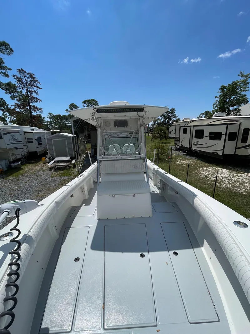 Slide: The Image of 1998 Regulator 26 Classic boat with center console, parked outdoors under a clear sky. - 25