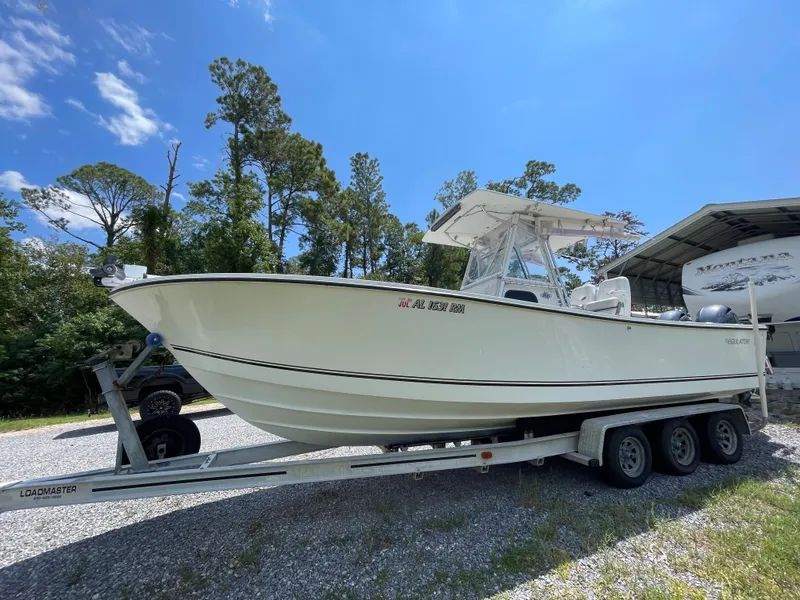 Slide: The Image of 1998 Regulator 26 Classic boat on a trailer in a sunny outdoor setting. - 4