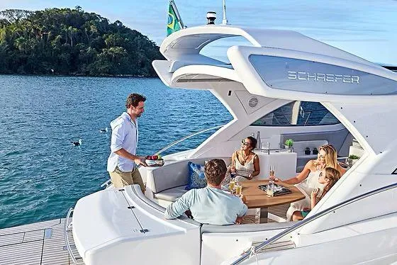 Slide: The Image of 2026 Schaefer 400 yacht with people enjoying a gathering on deck, scenic water backdrop. - 17