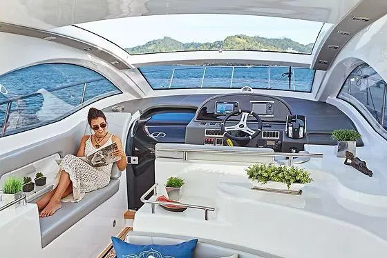 Slide: The Image of Luxurious 2026 Schaefer 400 yacht interior with woman relaxing, reading a magazine. - 5