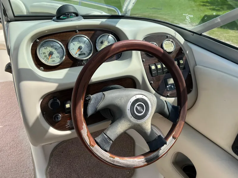 Slide: The Image of 2007 Chaparral 210 SSi boat dashboard with gauges and wooden steering wheel. - 24