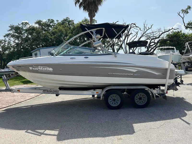 Slide: The Image of 2007 Chaparral 210 SSi boat on trailer, parked outdoors with trees in background. - 27