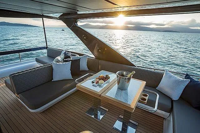 Slide: The Image of Luxurious Schaefer 600 yacht interior with sunset view, featuring elegant seating and dining setup. - 27