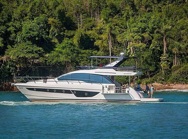 Slide: The Image of Luxury Schaefer 600 yacht cruising near lush green coastline, 2026 model. - 6