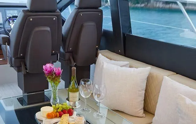 Slide: The Image of Luxurious Schaefer 660 yacht interior with wine, cheese, and flowers on a glass table. - 13